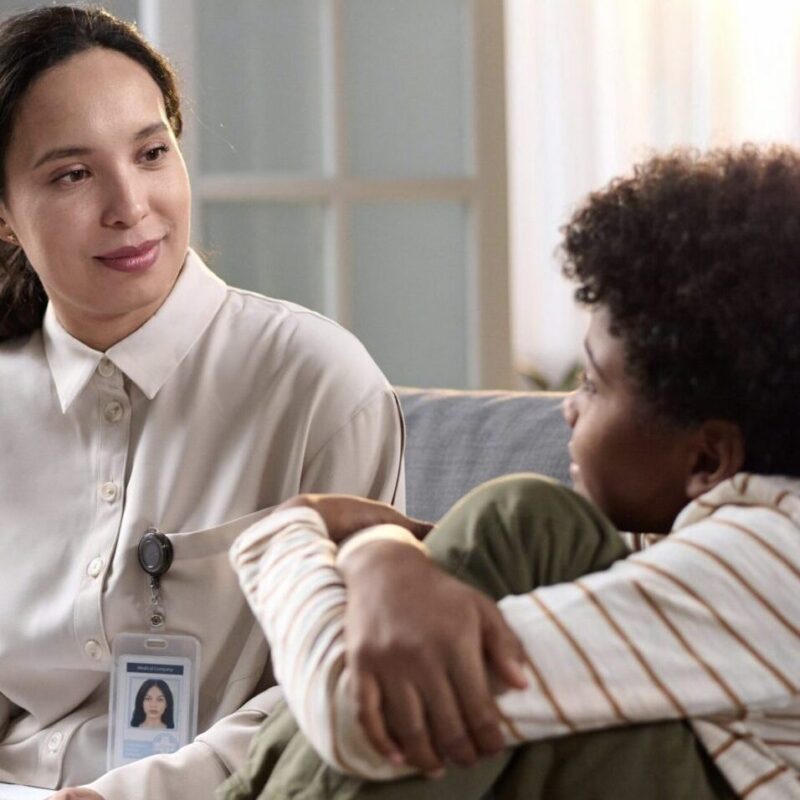 Licensed clinician working with child and caregiver during therapy session in NYC